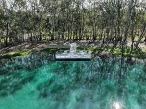 fishing pontoon in lake with trees in background