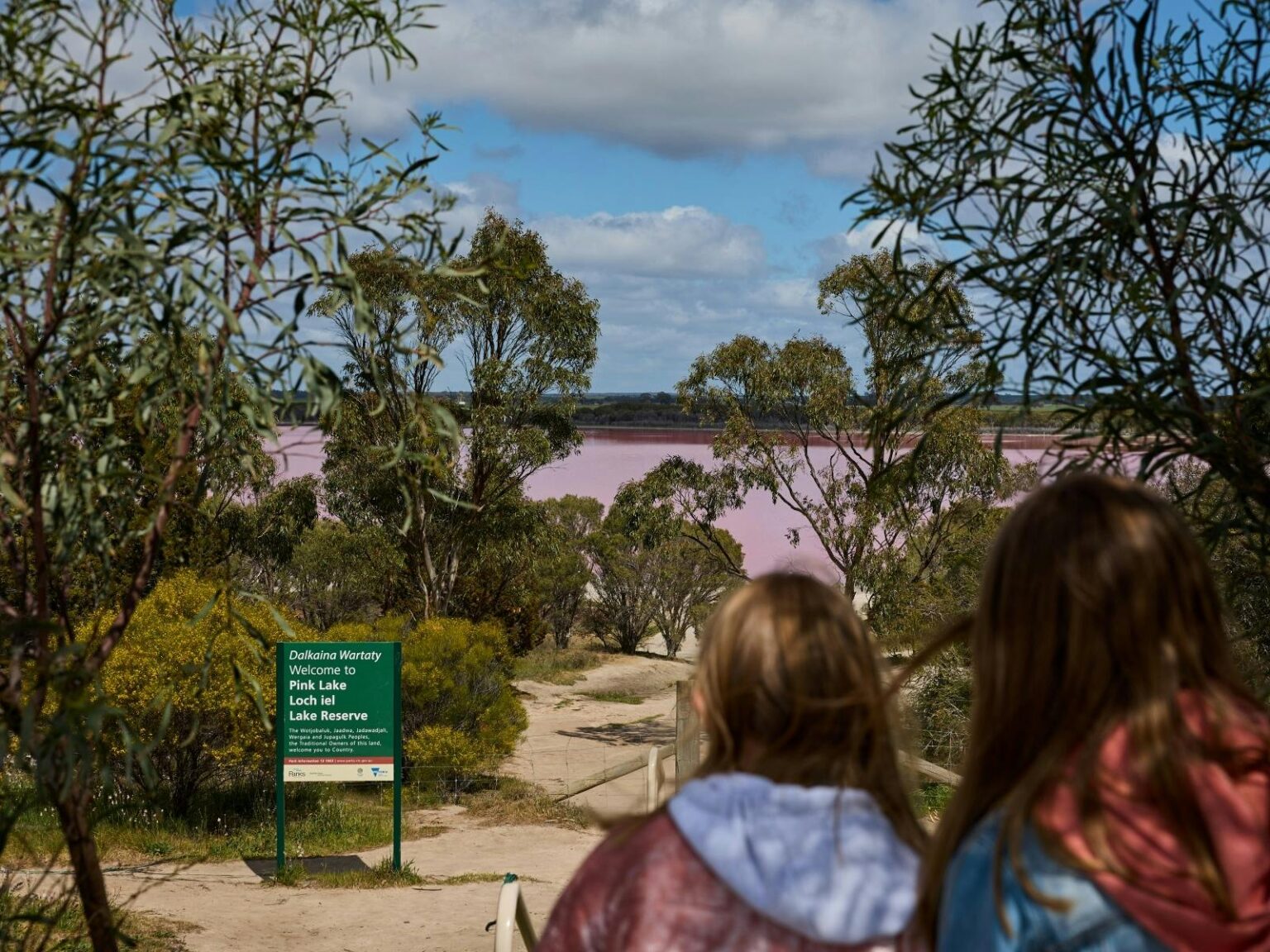 Pink Lake walk two girls looking down sandy walking track to pink lake