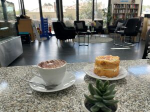 a photo of a cup of coffee and a cake.
