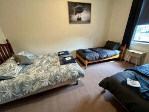Hotel style room with a queen bed and two single beds