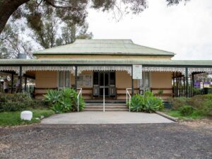 old weatherboard homestead with garden in front of veranda