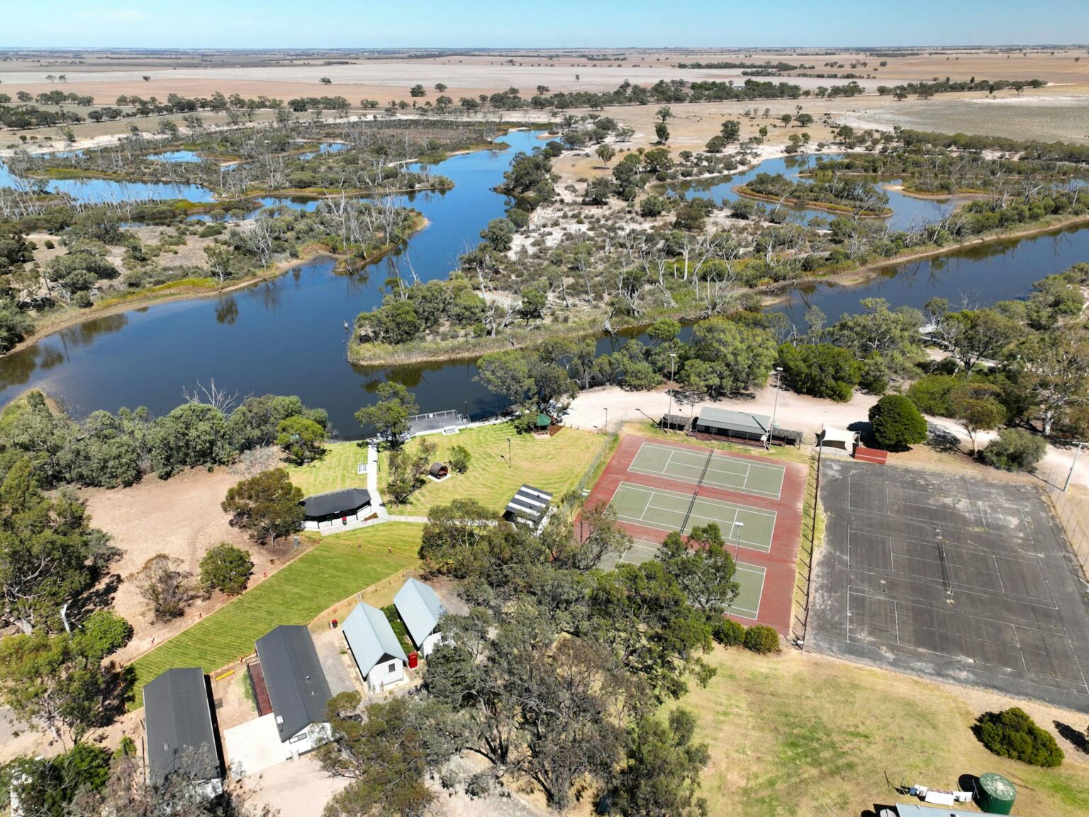 Aerial view of winding river with caravan park