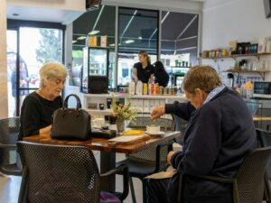 Two people sitting at a table enjoying a coffee and a counter in the background