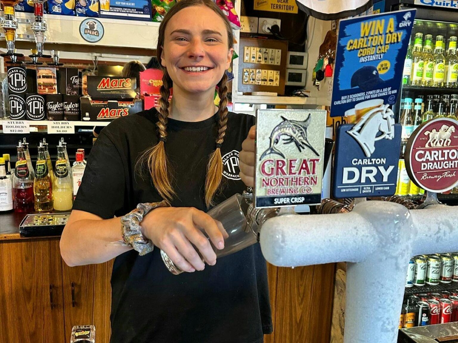 Image of young girl pouring a drink behind a bar