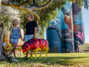 two children holding hands with ceramic red