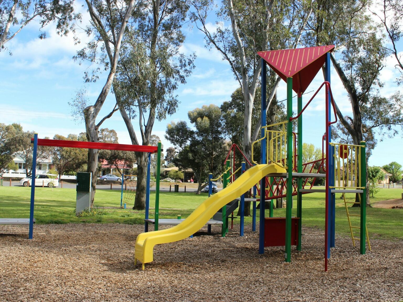 play equipment and slide with lawn and trees in background
