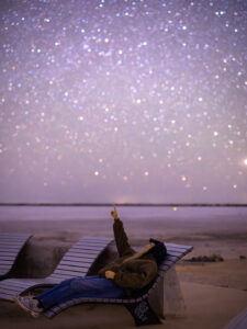 Person laying on a recliner looking at the night sky at Lake Tyrrell