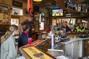 People sitting at the bar of a country pub