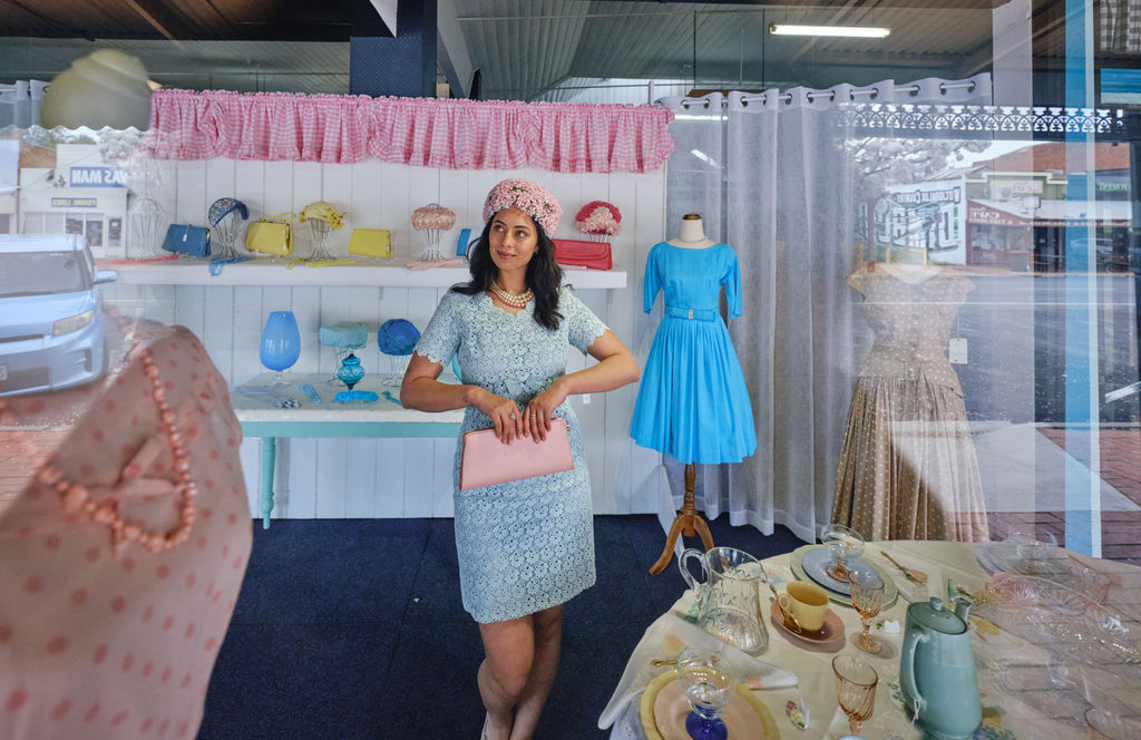 Woman dressed in vintage clothing standing in a shop window in Dimboola