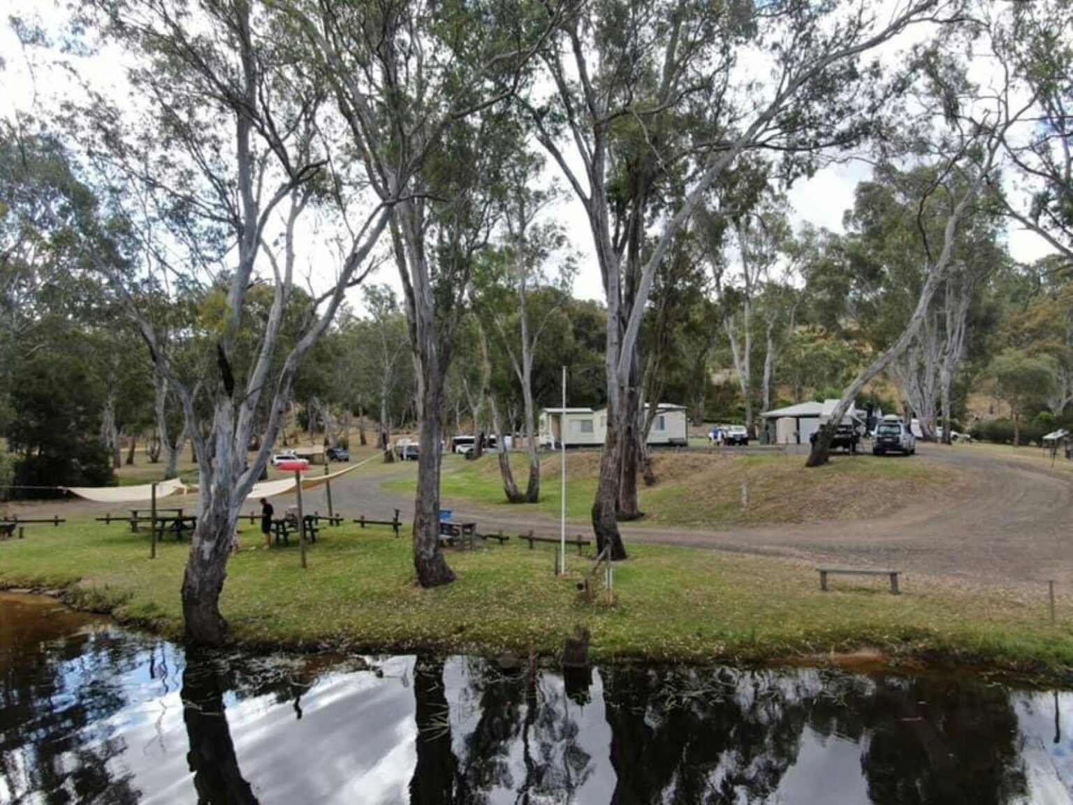 Lake in the foreground with vans