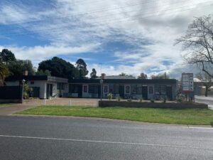 A full shot of the motel. A grey