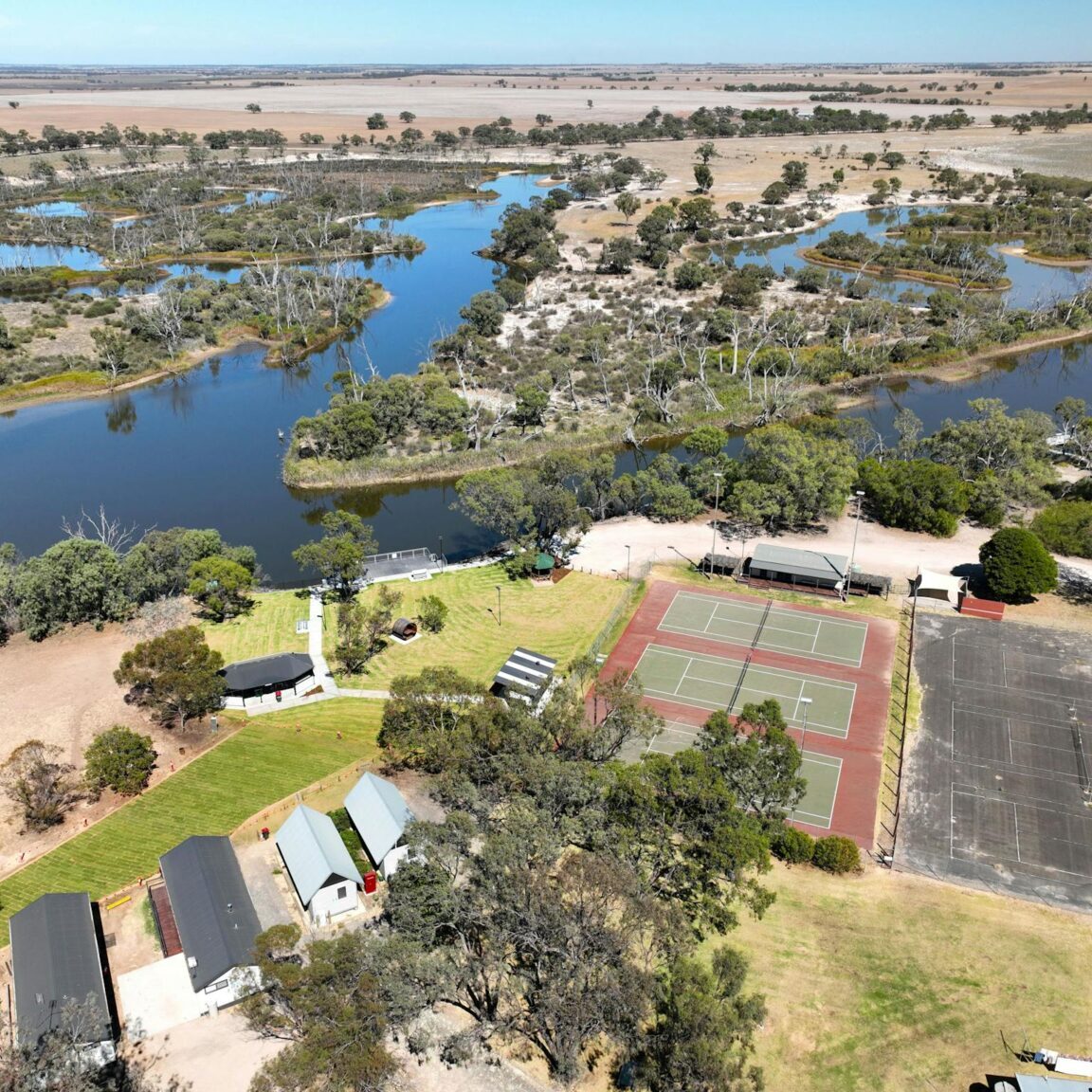 Aerial view of winding river with caravan park