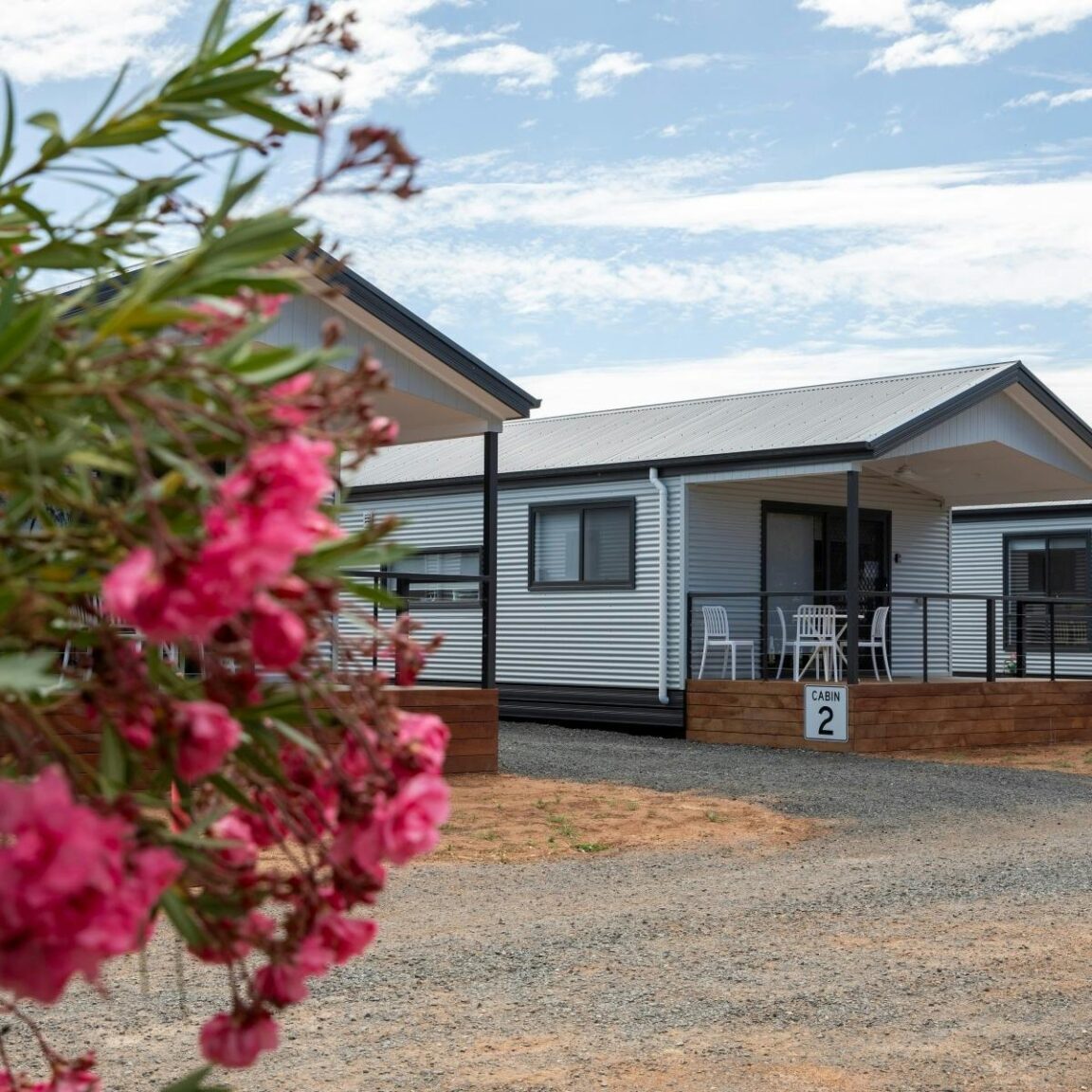 holiday cabins with pink native flowers in foreground