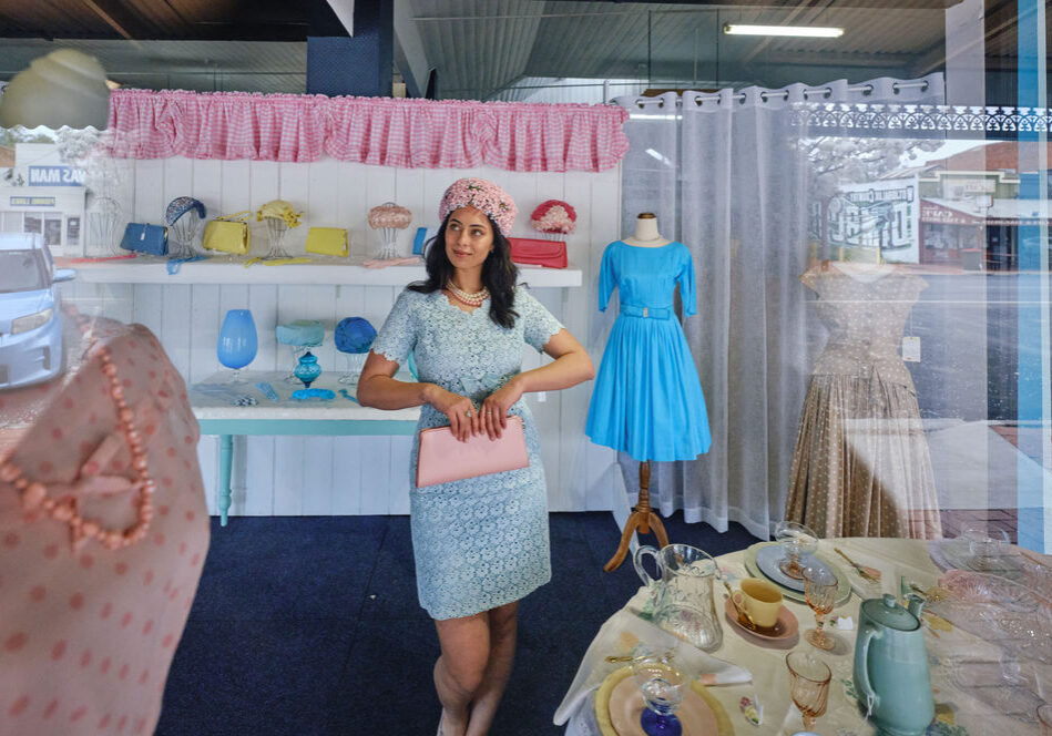 Woman dressed in vintage clothing standing in a shop window in Dimboola