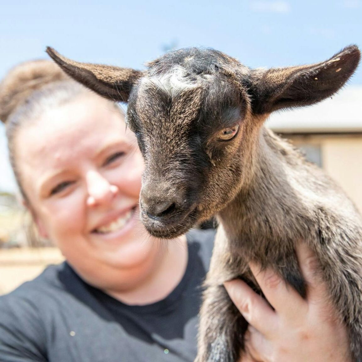 Woman holding a tiny goat