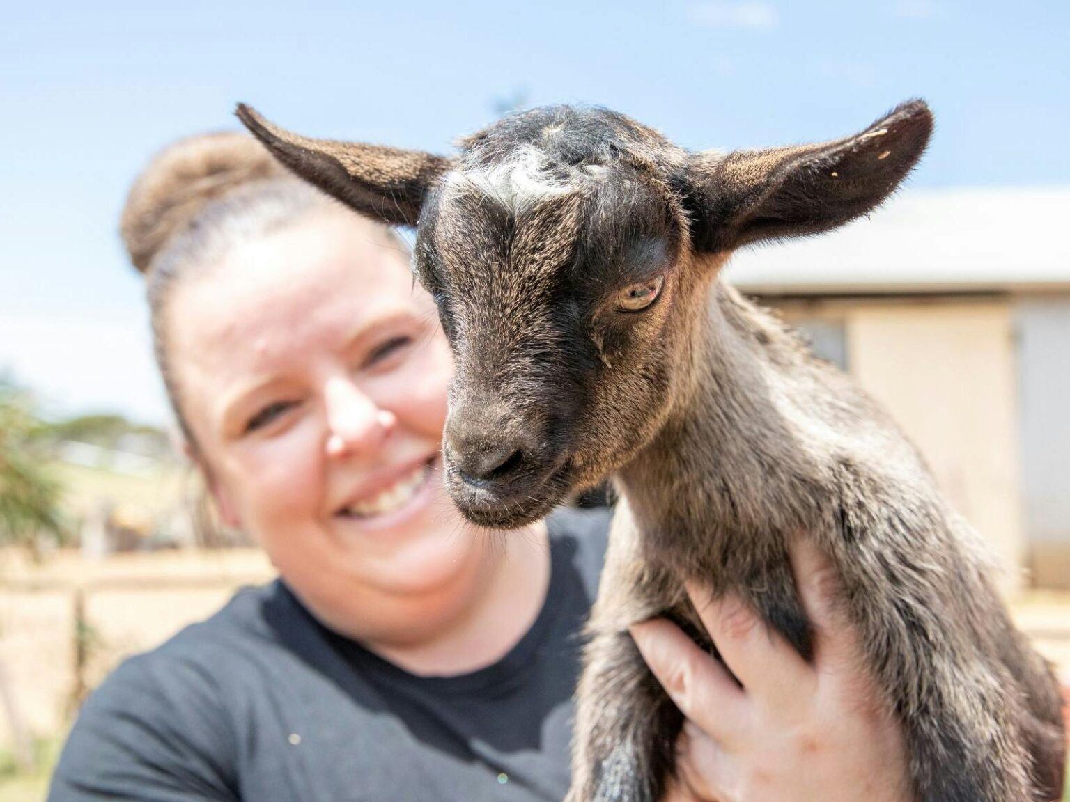 Woman holding a tiny goat