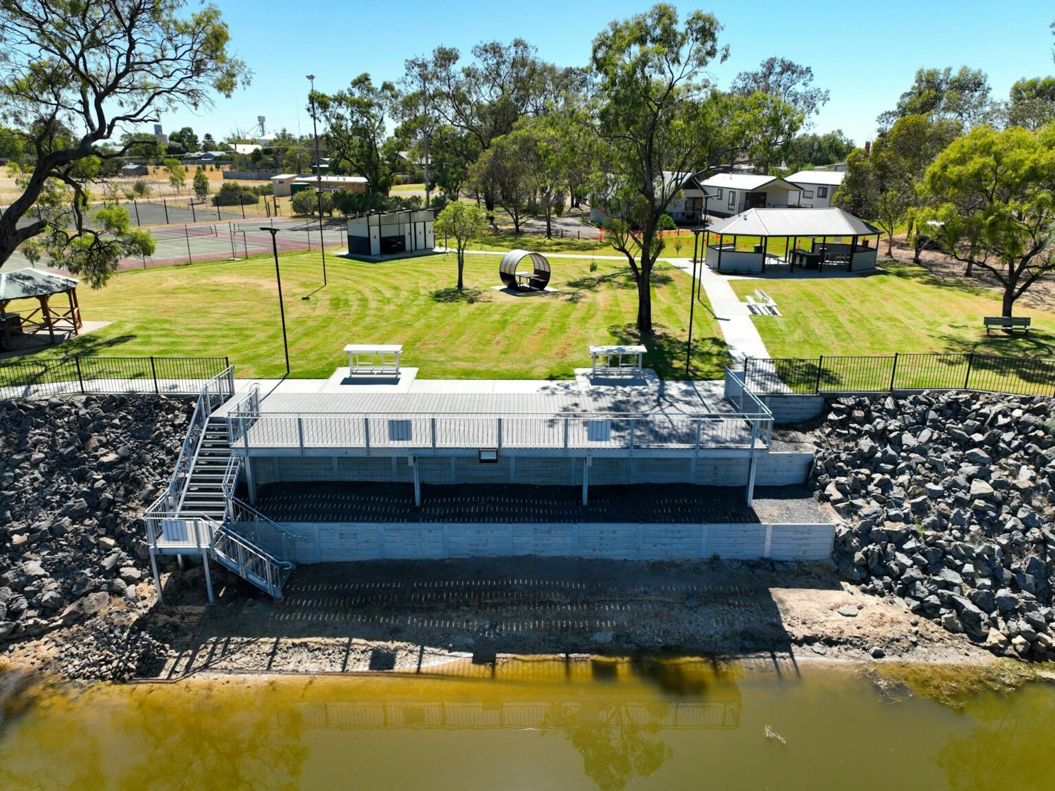 Aerial view of winding river with caravan park